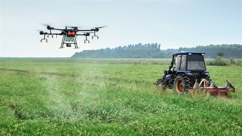 imagem de um drone sendo utilizado na lavoura ao lado lado de um trator