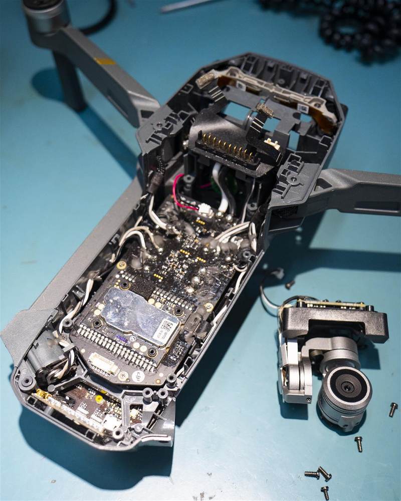 imagem de drone desmontado em cima de uma mesa de manutenção
