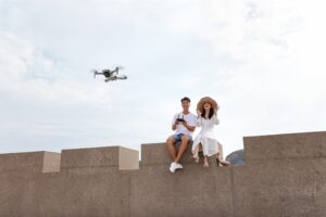 Casal sentados juntos enquanto usam drone de filmagem