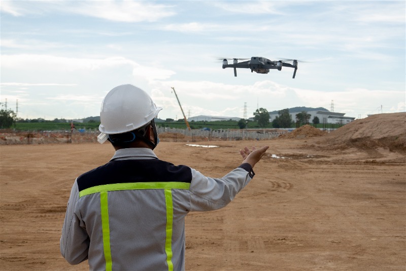 Imagem de um profissional do ramo da construção realizando um trabalho com drone