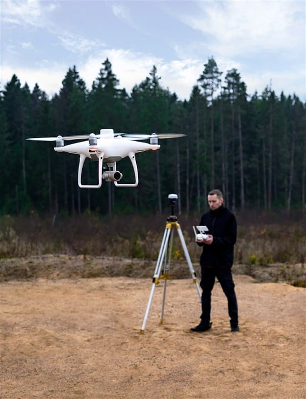 Imagem de uma pessoa manuseando um drone no campo